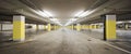 Front view empty underground supermarket parking with yellow concrete columns and white arrow on the ground Royalty Free Stock Photo