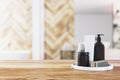 Front view of empty wooden table top in bathroom interior with blurred background and black bathroom accessories, product Royalty Free Stock Photo