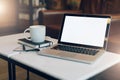 Front view. Empty workplace. On white coffee table is laptop with blank screen, cup of coffee, notebook, pen, newspaper. Royalty Free Stock Photo