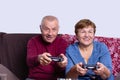 Front view of excited senior gray elderly , family couple of man and woman playing video game on a console, sitting on Royalty Free Stock Photo