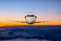 Front view of the executive aircraft flying in the sunrise sky Royalty Free Stock Photo