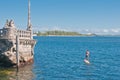 Male paddle boarding around a coral and concrete sculpture of a huge ship