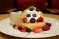 Fluffy Souffle Pancake with Fresh Whipped Cream and Mix Berries on White Plate with Syrup Pitcher Royalty Free Stock Photo