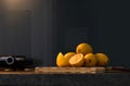 Front view of fresh whole and half lemons stacked on dark gray marble surface. Bright yellow citrus slices on blur kitchen Royalty Free Stock Photo