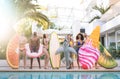 Front view of friends at swimming pool party with lilo airbed and swim wear - Youth vacation concept with happy guys and girls