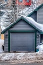 Front view of garage against a snow covered neighborhood landscape in winter Royalty Free Stock Photo