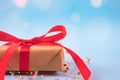 Front view of gift box with red bow on festive blue background with golden sparkles around and copyspace for your text. Christmas Royalty Free Stock Photo