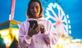 Front view girl pointing finger on screen smartphone on defocus background bokeh light in evening street attraction, woman using Royalty Free Stock Photo