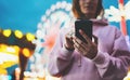 Front view girl pointing finger on screen smartphone on defocus background bokeh light in evening street attraction, woman using Royalty Free Stock Photo