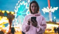 Front view girl pointing finger on screen smartphone on defocus background bokeh light in evening street attraction, woman using Royalty Free Stock Photo