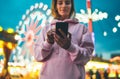 Front view girl pointing finger on screen smartphone on defocus background bokeh light in evening street attraction, woman using i Royalty Free Stock Photo