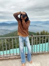 Front view of a good looking long haired young man photographer, taking photo with his DSLR camera while standing