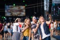 Group of young friends with smartphone at summer festival, taking selfie. Royalty Free Stock Photo