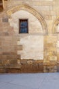 Front view of grunge stone bricks wall and small window at Darb al Ahmar District, Cairo, Egypt