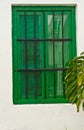 Green, shuttered, window with iron bares