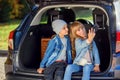 Front view of handsome 10-aged boy in hat and pretty 12-aged girl with blond long hair which taking photos on her phone Royalty Free Stock Photo