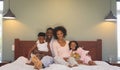 Happy African American family relaxing on bed and looking at camera Royalty Free Stock Photo