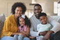 Happy African American family sitting on sofa and looking at Royalty Free Stock Photo