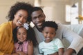 Happy African American family sitting on sofa and looking at Royalty Free Stock Photo
