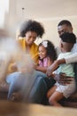 Front view of happy African American parents with their cute children using digital tablet on sofa Royalty Free Stock Photo