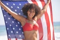 Woman in bikini holding american flag on the beach Royalty Free Stock Photo