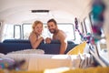 Couple looking at camera in camper van at beach Royalty Free Stock Photo