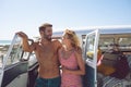 Couple talking with each other near camper van at beach in the sunshine Royalty Free Stock Photo