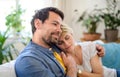 Happy couple in love sitting indoors at home, hugging.