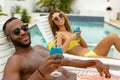 Couple having cocktail drink while relaxing on a sun lounger Royalty Free Stock Photo