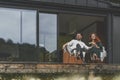 Front view of happy family sitting outdoor on the terrace of big country house Royalty Free Stock Photo