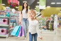 Girl keeping hand of mom and running forwardn in toy store Royalty Free Stock Photo