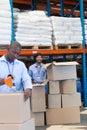 Male staff looking at camera while checking stock in warehouse Royalty Free Stock Photo