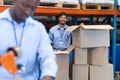 Male staff looking at camera while checking stock in warehouse Royalty Free Stock Photo