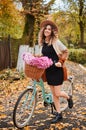 Happy young woman walking with stylish bicycle in park. Royalty Free Stock Photo