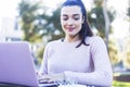 Front view of a happy student girl working with a laptop in a green park of an university campus Royalty Free Stock Photo