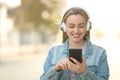 Front view of happy teen listening to music outdoors Royalty Free Stock Photo