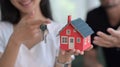 Happy young couple holding house model and keys. New house, insurance and real estate concept. Royalty Free Stock Photo