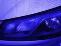 Front view of Headlight classic blue color covered with raindrops. Car exterior details of modern sport car Royalty Free Stock Photo