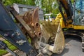 Front view of a heavy equipment excavator bucket on the side of a residential street in front of a house Royalty Free Stock Photo