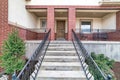 Front view of home with stairs going up to the elevated porch and brown door Royalty Free Stock Photo