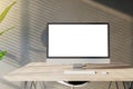 Front view of a home workplace with wooden desk with blank white screen modern computer on dark wall background in sunny interior Royalty Free Stock Photo