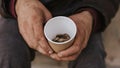 front view homeless man holding cup with coins. High quality photo