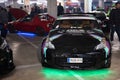 black Nissan 350Z with green neon lights on the underbody tuned by HKS parked in a parking lot