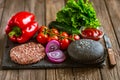 Front view of ingredients for beef black burger on a black stone board with knife. Delicious food Royalty Free Stock Photo