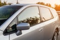 Front view of a Japanese car in the body of a hatchback of the side of a silver station wagon in a parking lot with green Royalty Free Stock Photo