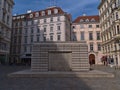 Front view of the Judenplatz Holocaust Memorial in the downtown of Vienna, Austria surrounded by old buildings.
