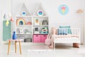 Front view of a kid`s room interior with a table, shelves with b Royalty Free Stock Photo