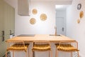 Front view of kitchen table island with trendy design high chairs. Wooden top and chairs in single honey color palette