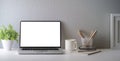 Front view laptop computer, coffee cup, stationery and houseplant on white table. Home office desk, Blank screen for your Royalty Free Stock Photo