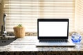 Front view of laptop with white screen in a kitchen with soft and warm light Royalty Free Stock Photo